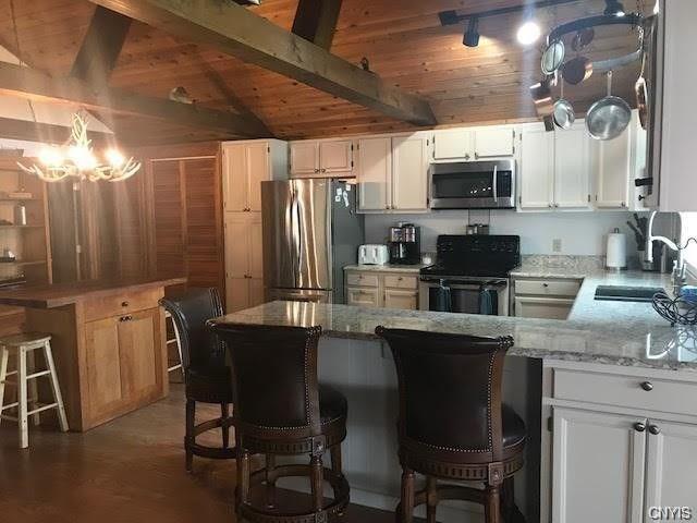 kitchen featuring a notable chandelier, white cabinetry, appliances with stainless steel finishes, and sink