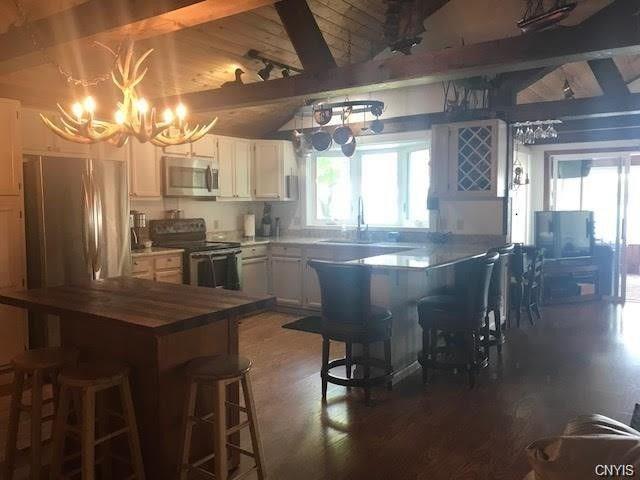 kitchen with dark hardwood / wood-style flooring, a notable chandelier, a wealth of natural light, and stainless steel appliances