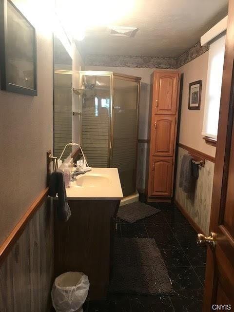 bathroom with an enclosed shower, tile floors, and large vanity