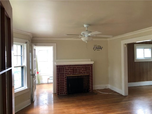 unfurnished living room featuring plenty of natural light, ceiling fan, wood-type flooring, and a fireplace