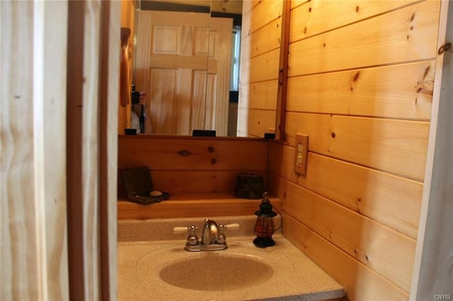 bathroom with wooden walls and vanity