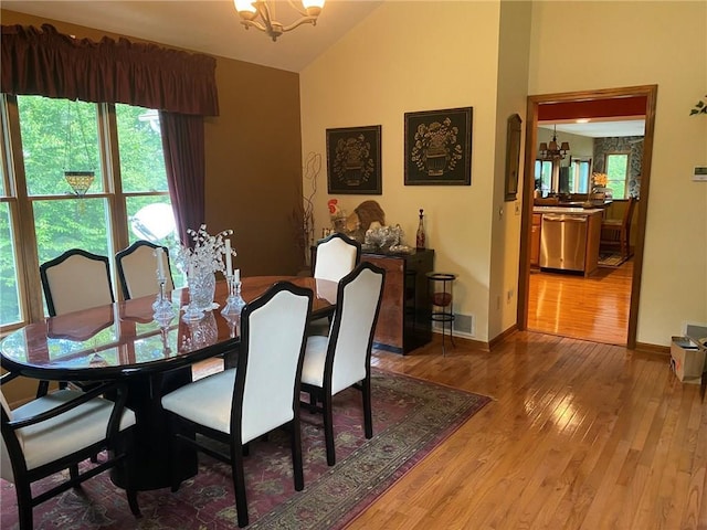 dining room featuring an inviting chandelier, dark hardwood / wood-style floors, and vaulted ceiling