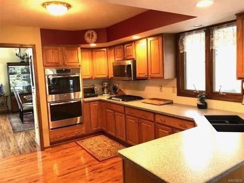 kitchen featuring appliances with stainless steel finishes, kitchen peninsula, sink, and light hardwood / wood-style flooring