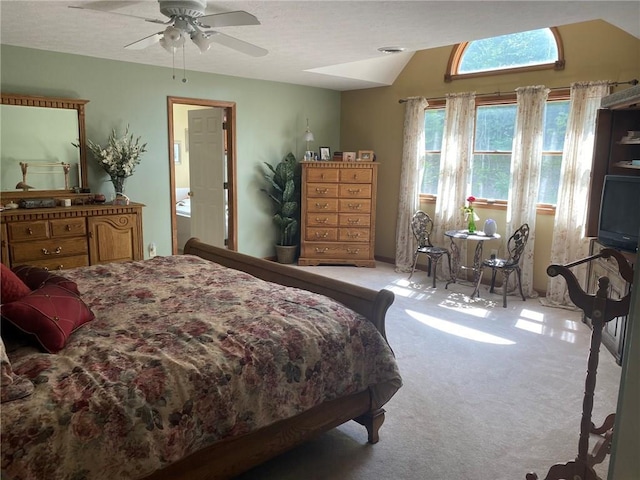 bedroom with ceiling fan, light carpet, and ensuite bathroom