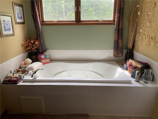 bathroom featuring a relaxing tiled bath and plenty of natural light