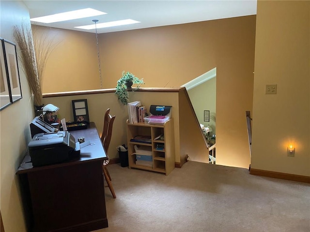 carpeted office space featuring a skylight