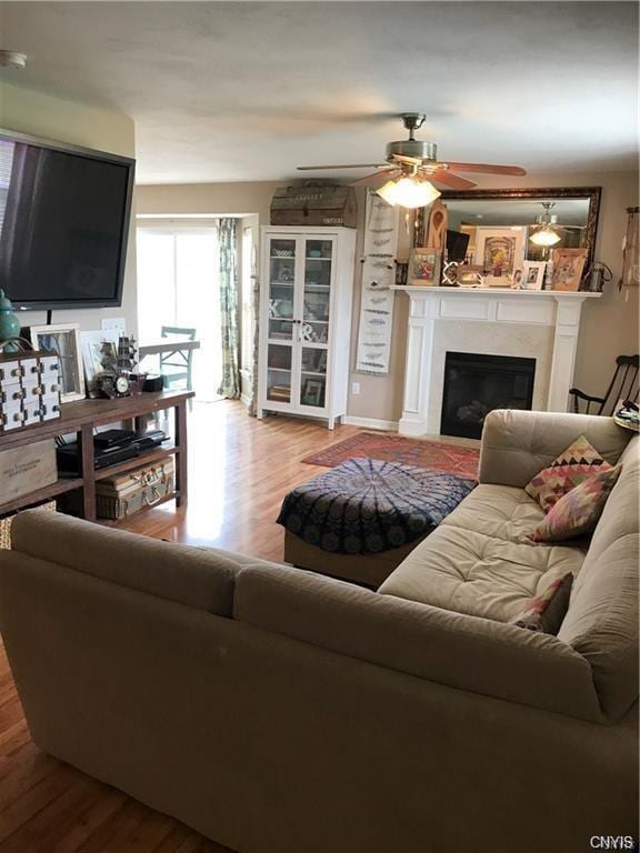 living room with ceiling fan and light wood-type flooring