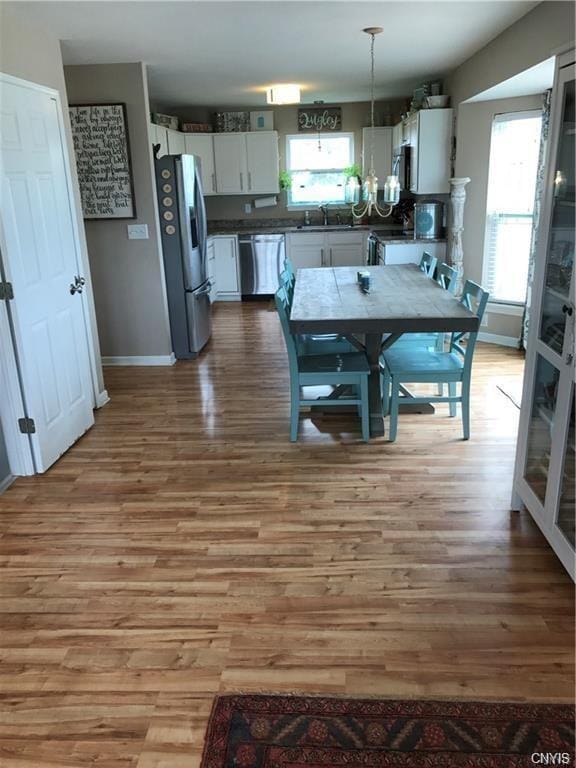 dining area featuring light hardwood / wood-style floors, sink, and a chandelier