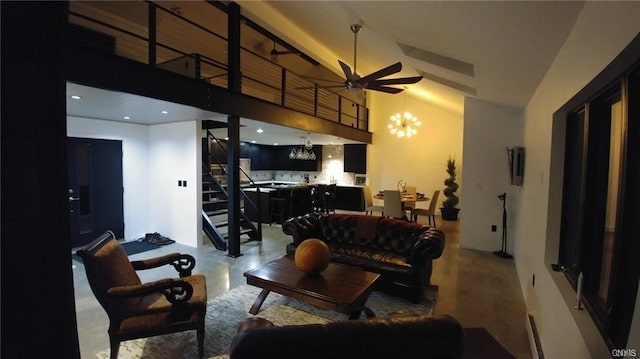 living room with a high ceiling and ceiling fan with notable chandelier