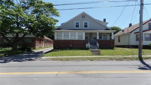 bungalow-style home featuring a porch and a front lawn