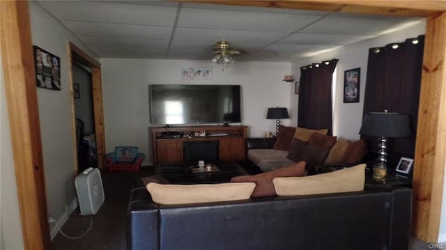 living room featuring a paneled ceiling and ceiling fan