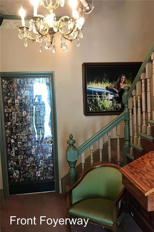 entryway featuring a chandelier and dark carpet