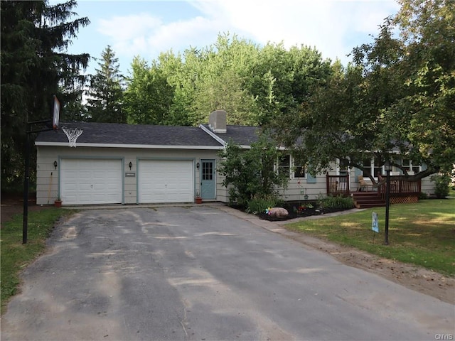 ranch-style house featuring a deck, a front lawn, and a garage