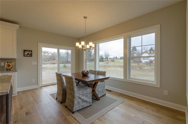 dining room featuring an inviting chandelier and light wood-type flooring