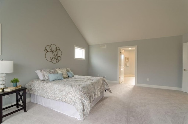 carpeted bedroom with high vaulted ceiling and connected bathroom