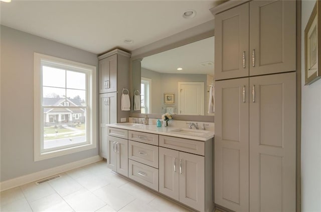 bathroom with dual sinks, vanity with extensive cabinet space, and tile flooring