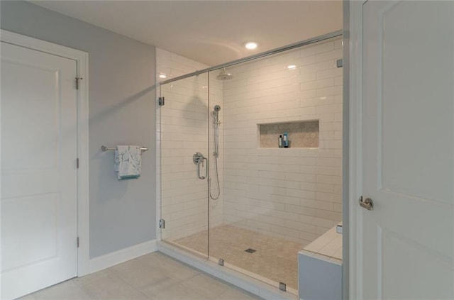 bathroom with an enclosed shower and tile flooring