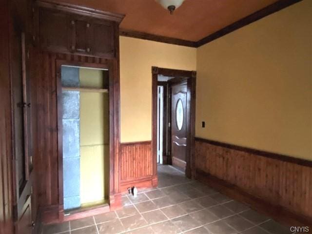 interior space with crown molding and tile floors