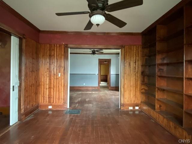 unfurnished room featuring wooden walls, ceiling fan, and dark hardwood / wood-style flooring