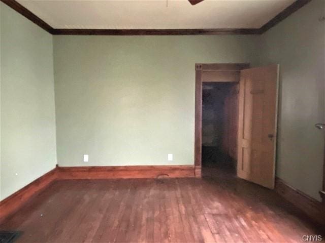 unfurnished room featuring ornamental molding and dark hardwood / wood-style floors