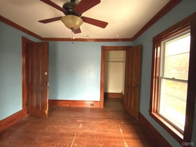 empty room featuring ceiling fan, crown molding, and dark hardwood / wood-style floors