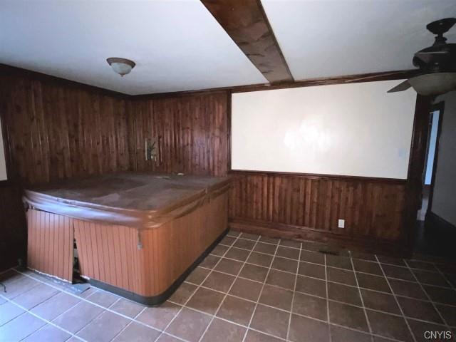 interior space featuring ceiling fan, wooden walls, pool table, and dark tile flooring