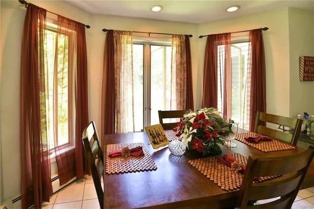 tiled dining area featuring baseboard heating and plenty of natural light