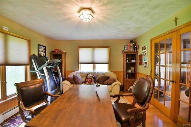 office area with light hardwood / wood-style flooring, a baseboard heating unit, and french doors