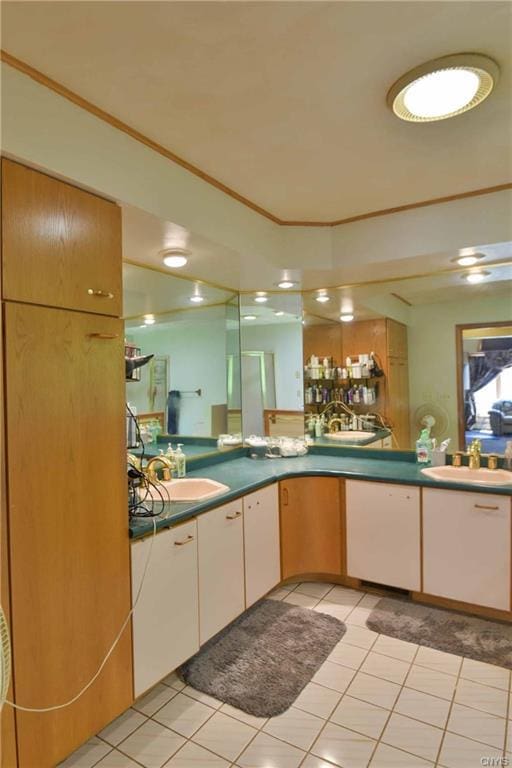 kitchen with crown molding, light tile floors, and sink