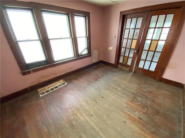 empty room with french doors and dark hardwood / wood-style flooring