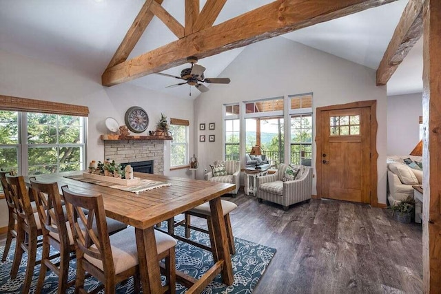 dining area with ceiling fan, beam ceiling, dark wood-type flooring, a fireplace, and high vaulted ceiling