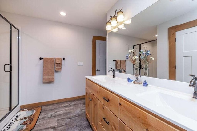 bathroom with hardwood / wood-style flooring, an enclosed shower, and vanity