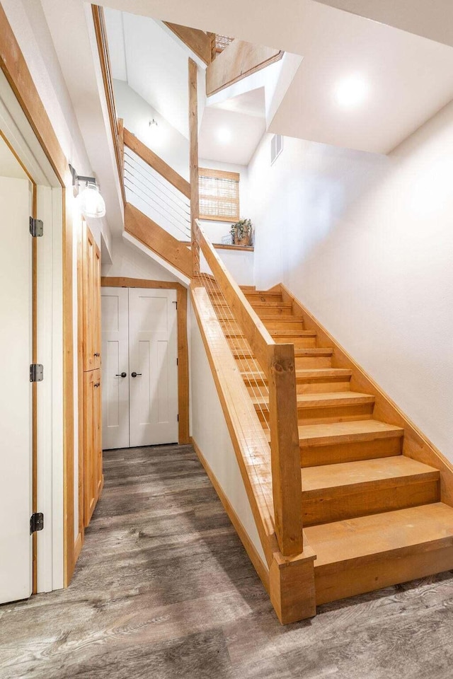 staircase featuring lofted ceiling and hardwood / wood-style floors