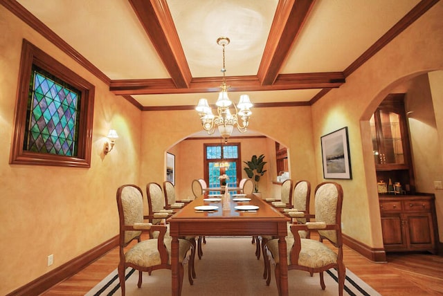 dining space with hardwood / wood-style flooring, crown molding, beam ceiling, and a chandelier