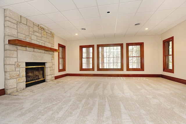 unfurnished living room with a fireplace, light colored carpet, and a paneled ceiling