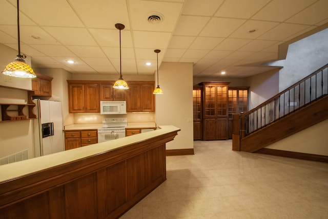 kitchen featuring a paneled ceiling, white appliances, and decorative light fixtures