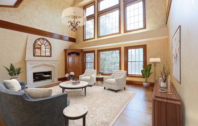 living room featuring a towering ceiling, an inviting chandelier, and hardwood / wood-style flooring