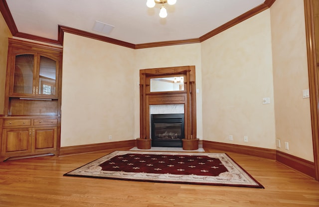 unfurnished living room with a fireplace, crown molding, and hardwood / wood-style floors