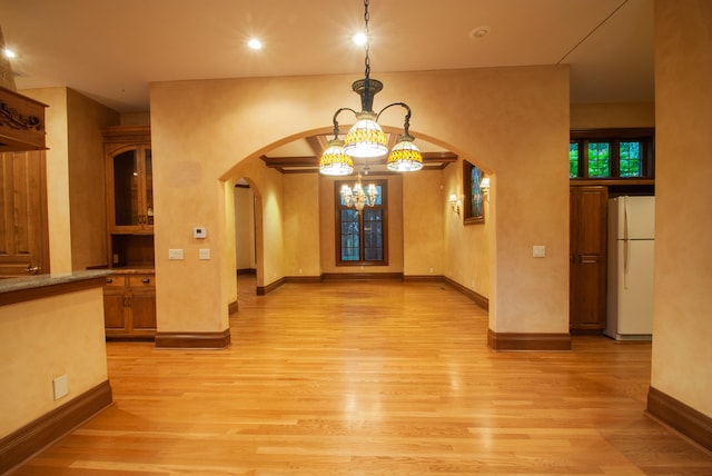 interior space with an inviting chandelier and light hardwood / wood-style floors