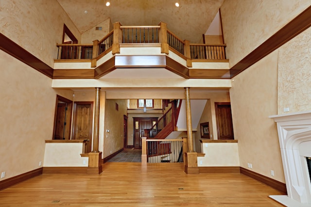 interior space featuring a towering ceiling and light hardwood / wood-style flooring