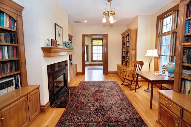 sitting room with light wood-type flooring and a notable chandelier