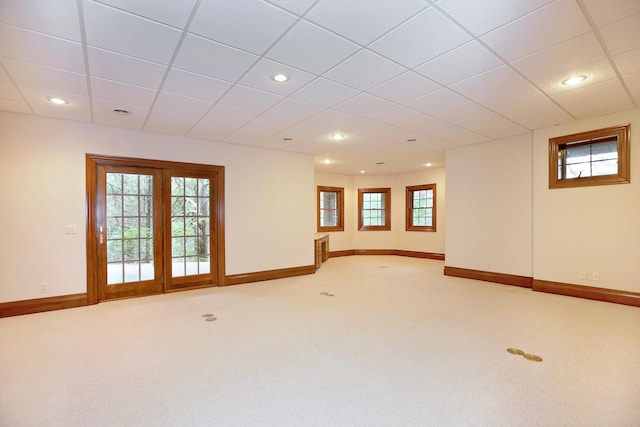 carpeted spare room featuring a drop ceiling