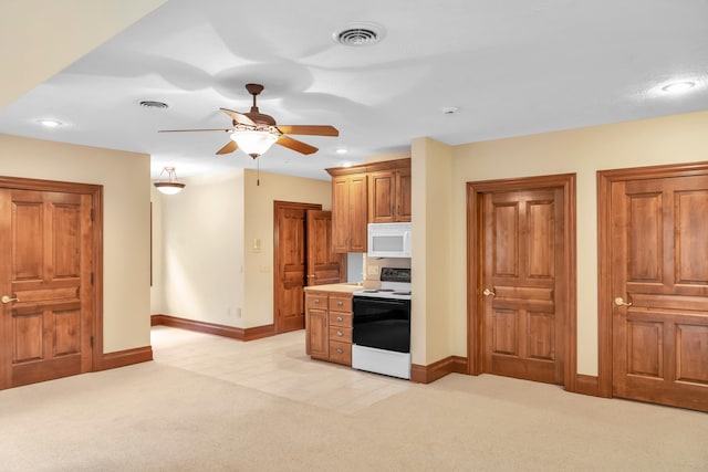 kitchen featuring white appliances, light colored carpet, and ceiling fan