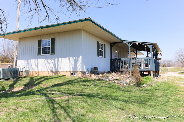 view of home's exterior with a wooden deck, a lawn, and central air condition unit