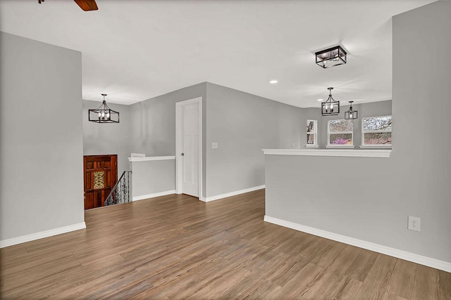 unfurnished living room featuring a chandelier and hardwood / wood-style flooring