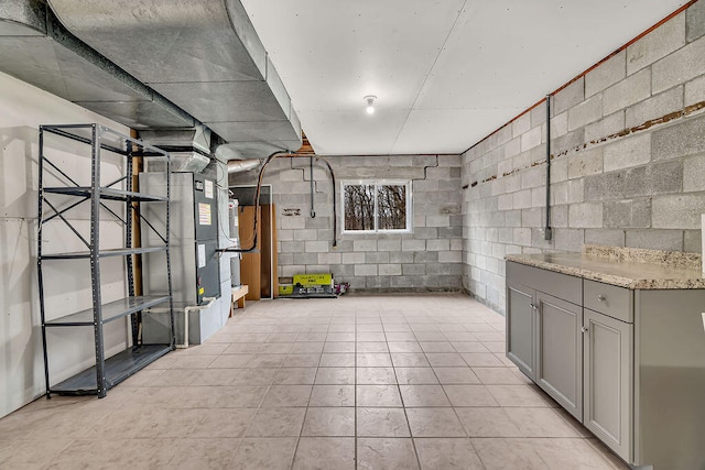 basement featuring heating unit and light tile patterned floors