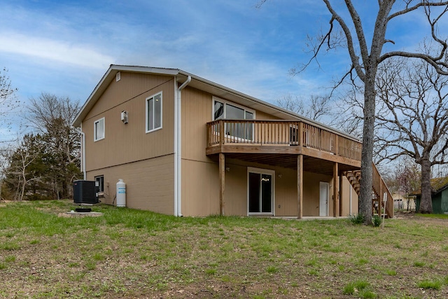 back of property featuring a deck, cooling unit, and a yard