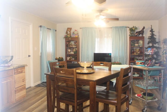 dining space with wood-type flooring and ceiling fan