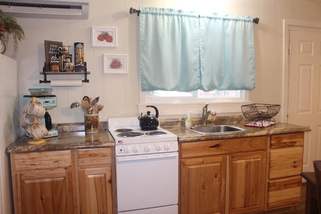 kitchen featuring sink, dark stone counters, and white range