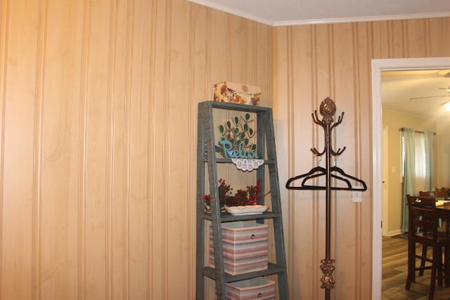 room details with ornamental molding, wooden walls, and wood-type flooring